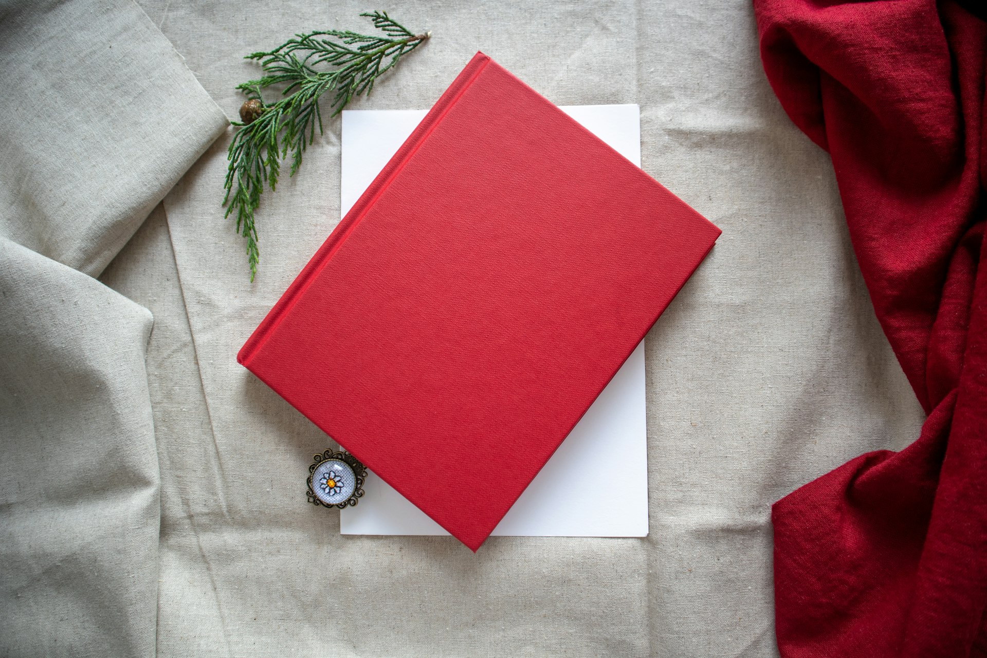 A red book sitting on top of a white sheet